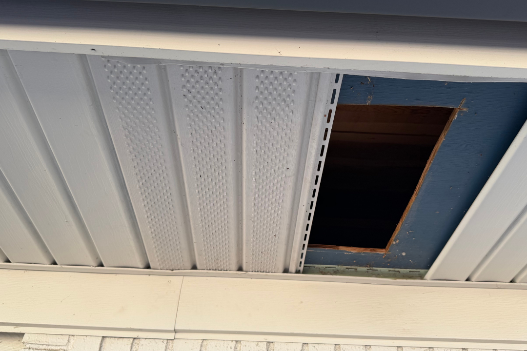 New perforated vinyl soffit vent installed next to old rotted open hole — before/after in single frame