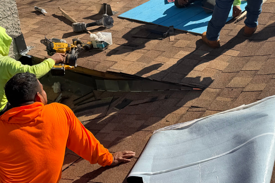 Two GCR crew members doing skylight install — green GCR hoodie with branding visible on back, orange hoodie crew, DeWalt tools, flashing, ice & water shield