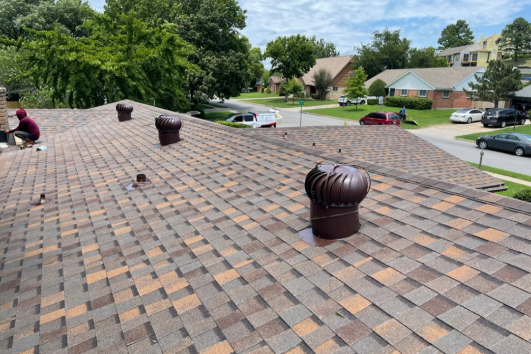 Three turbine vents on fresh Weathered Wood roof — crew working, GCR truck on street, lush green Tulsa summer