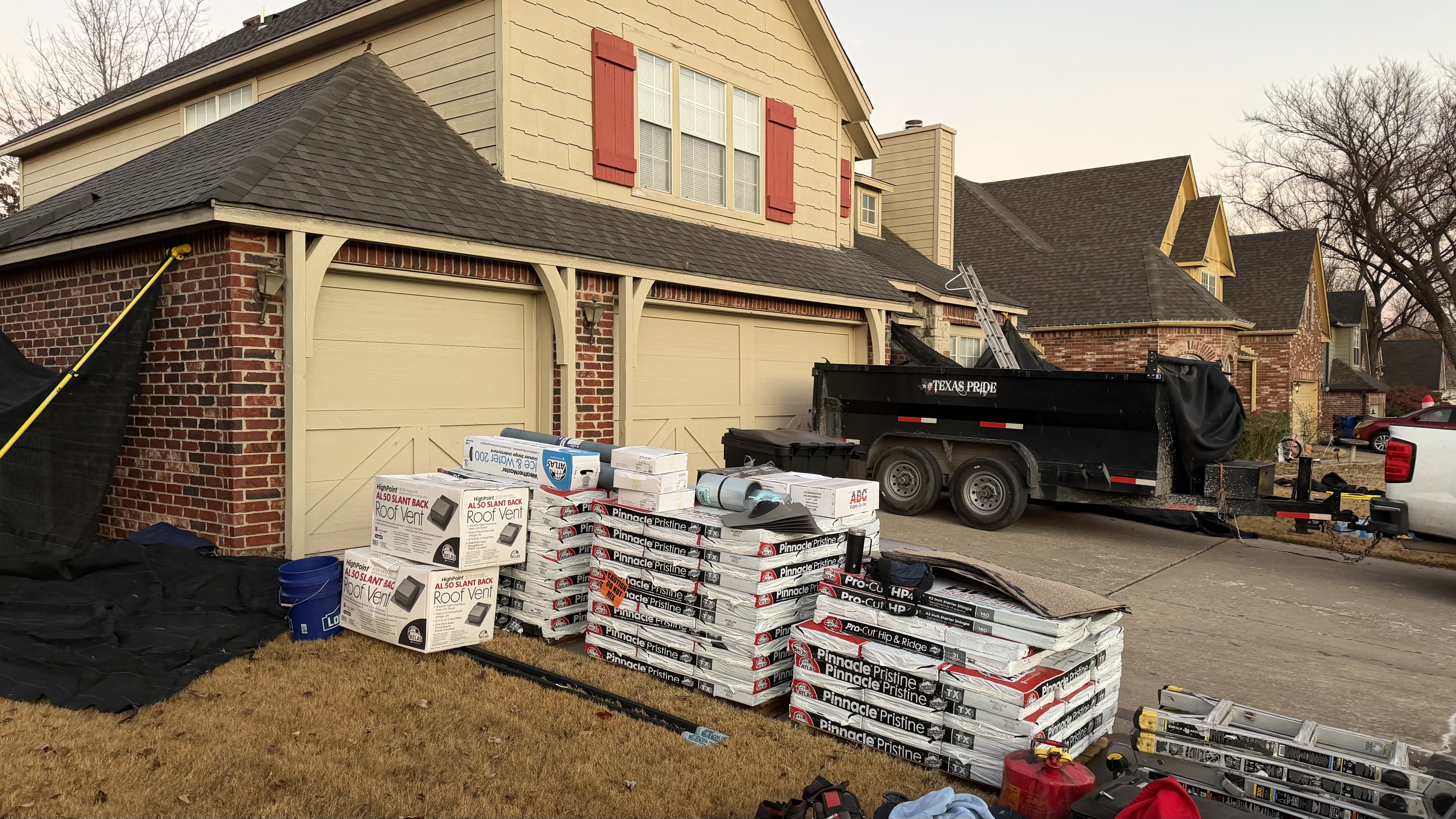 Job site staging — Pinnacle Pristine bundles, vents, ice & water, dump trailer