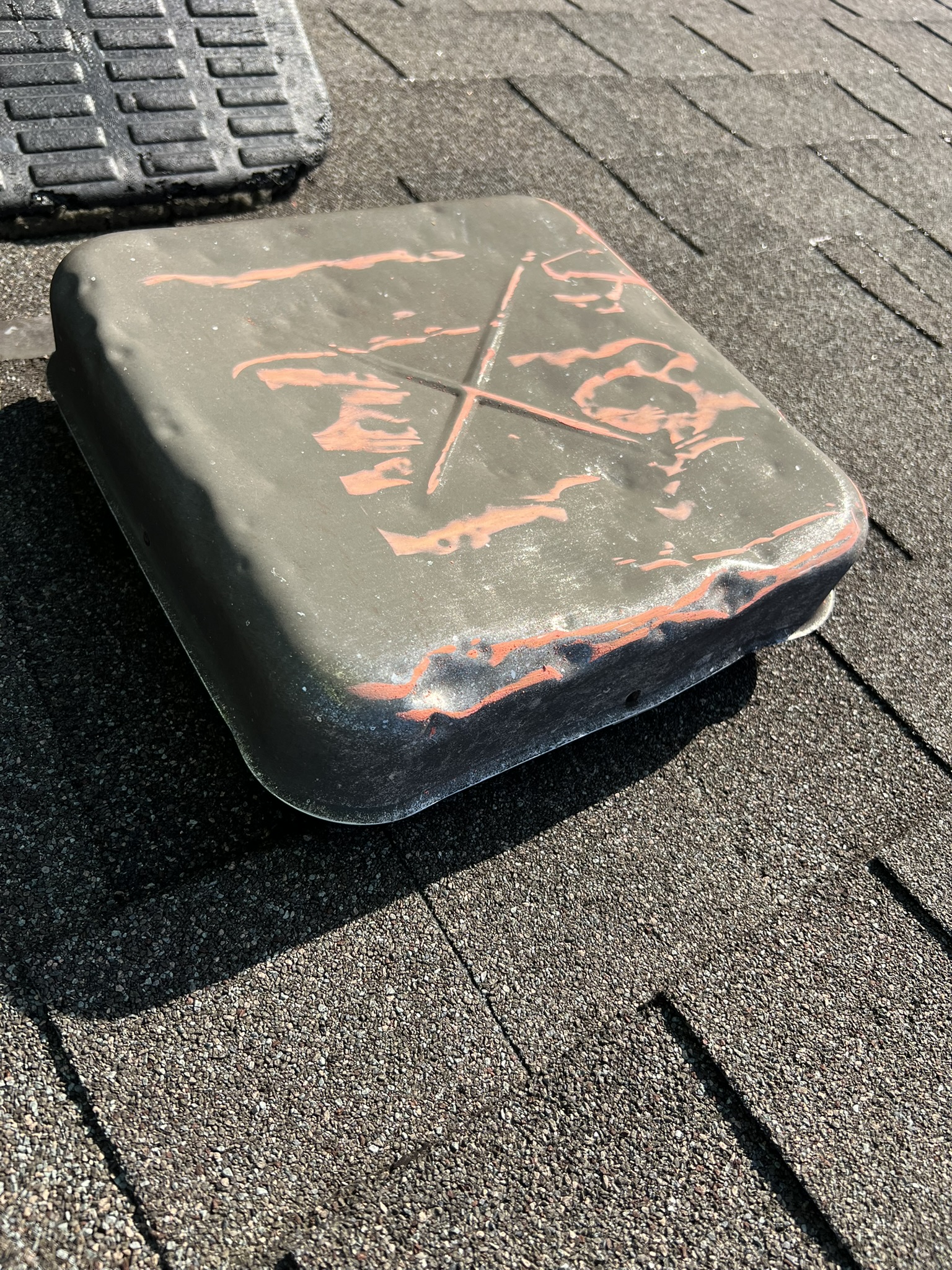 Severely dented black box vent with orange adjuster paint markings