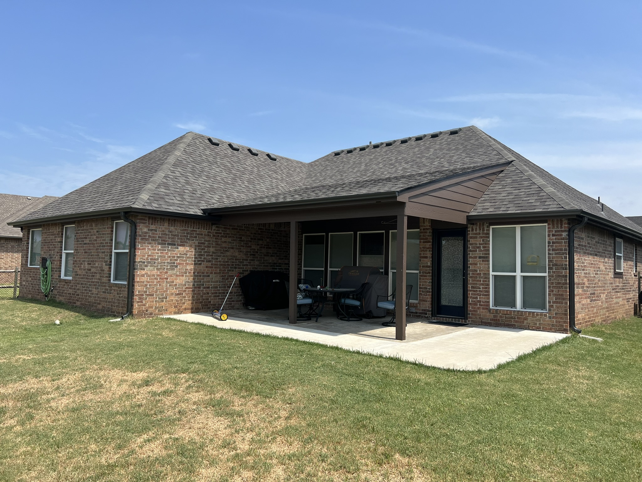 Finished roof on Tulsa brick home with proper ventilation installed, blue sky