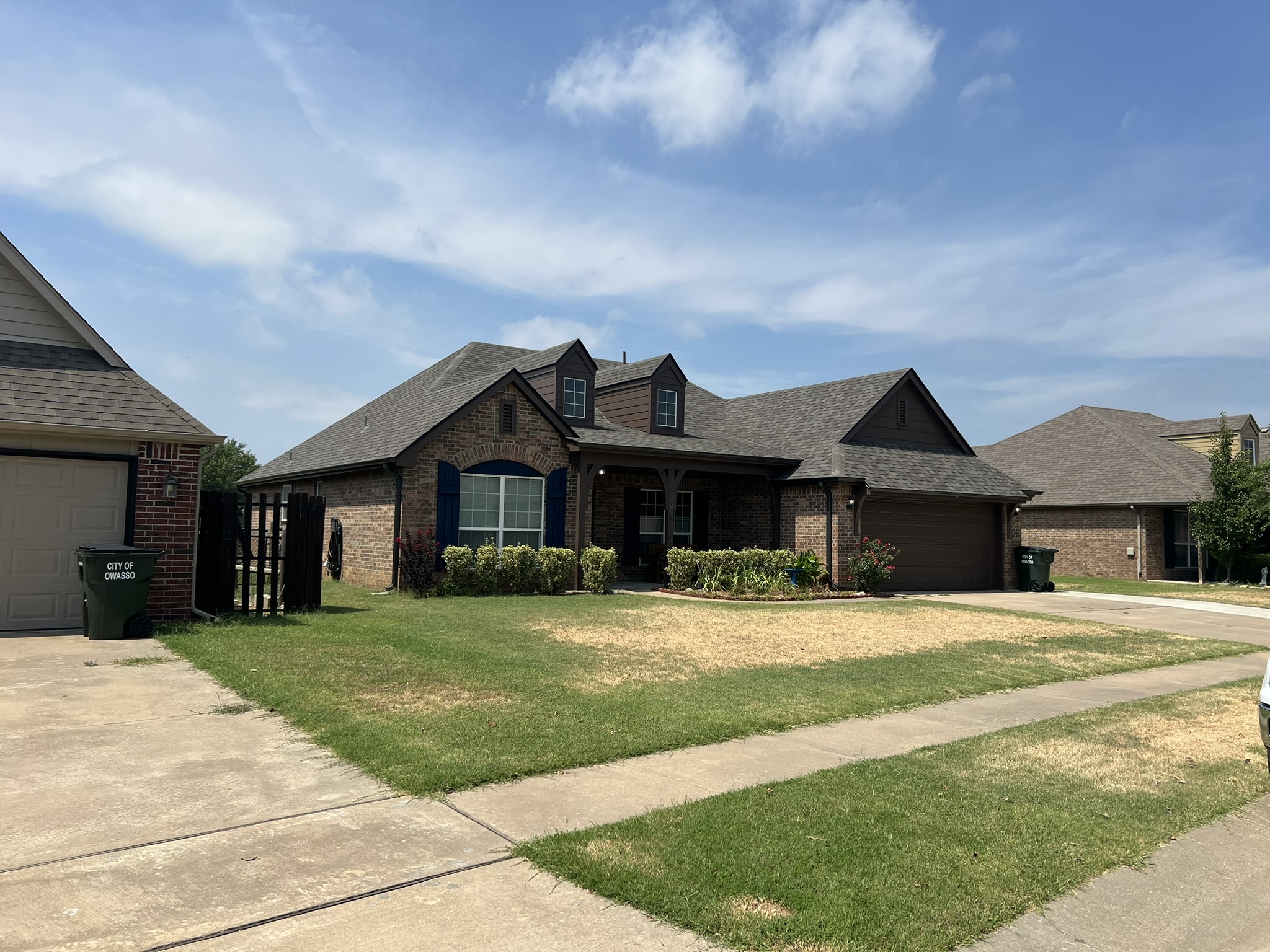 Finished CertainTeed roof on Owasso Oklahoma brick home with blue sky