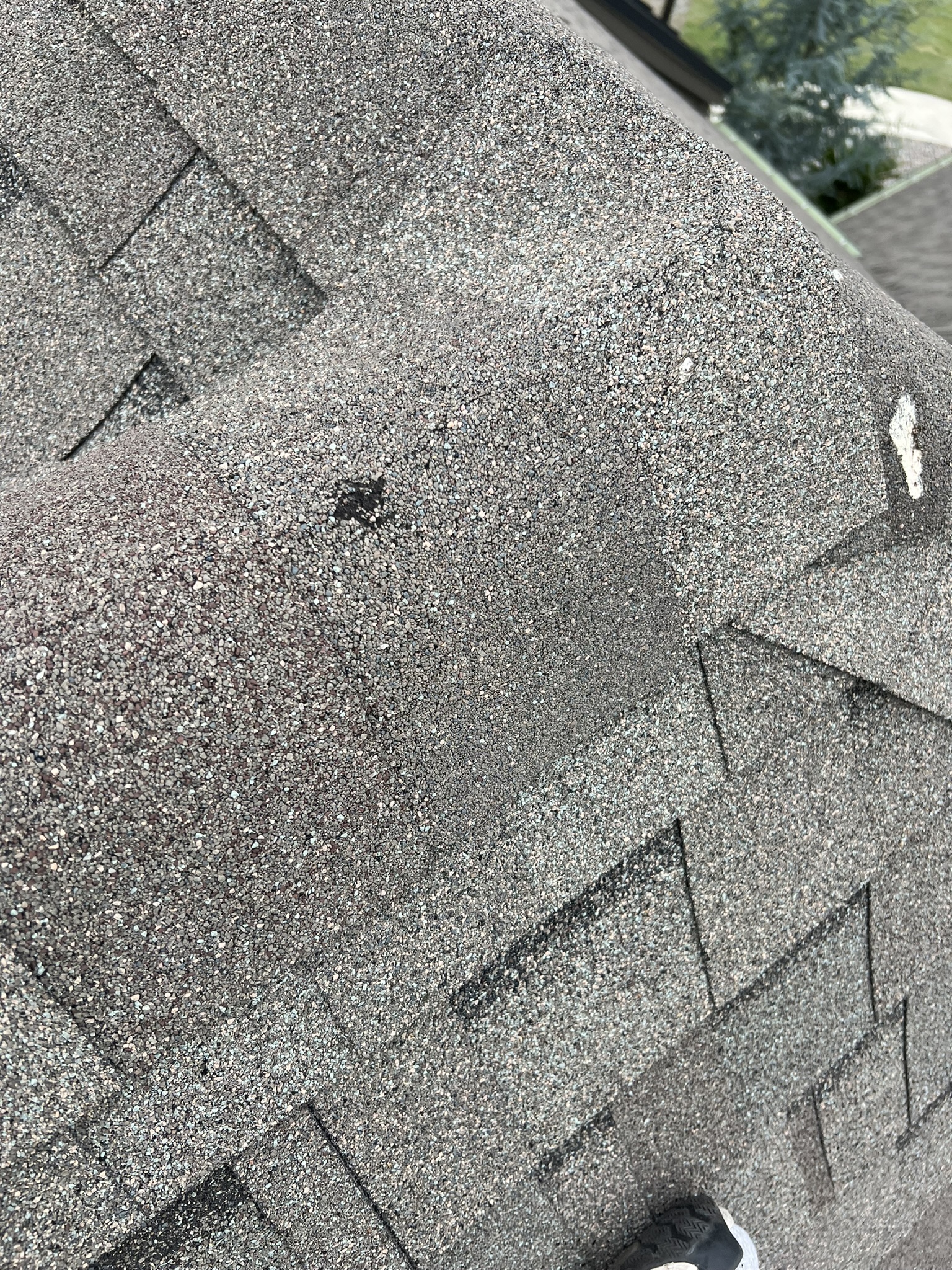 Hail bruising visible on ridge cap shingles after Oklahoma storm
