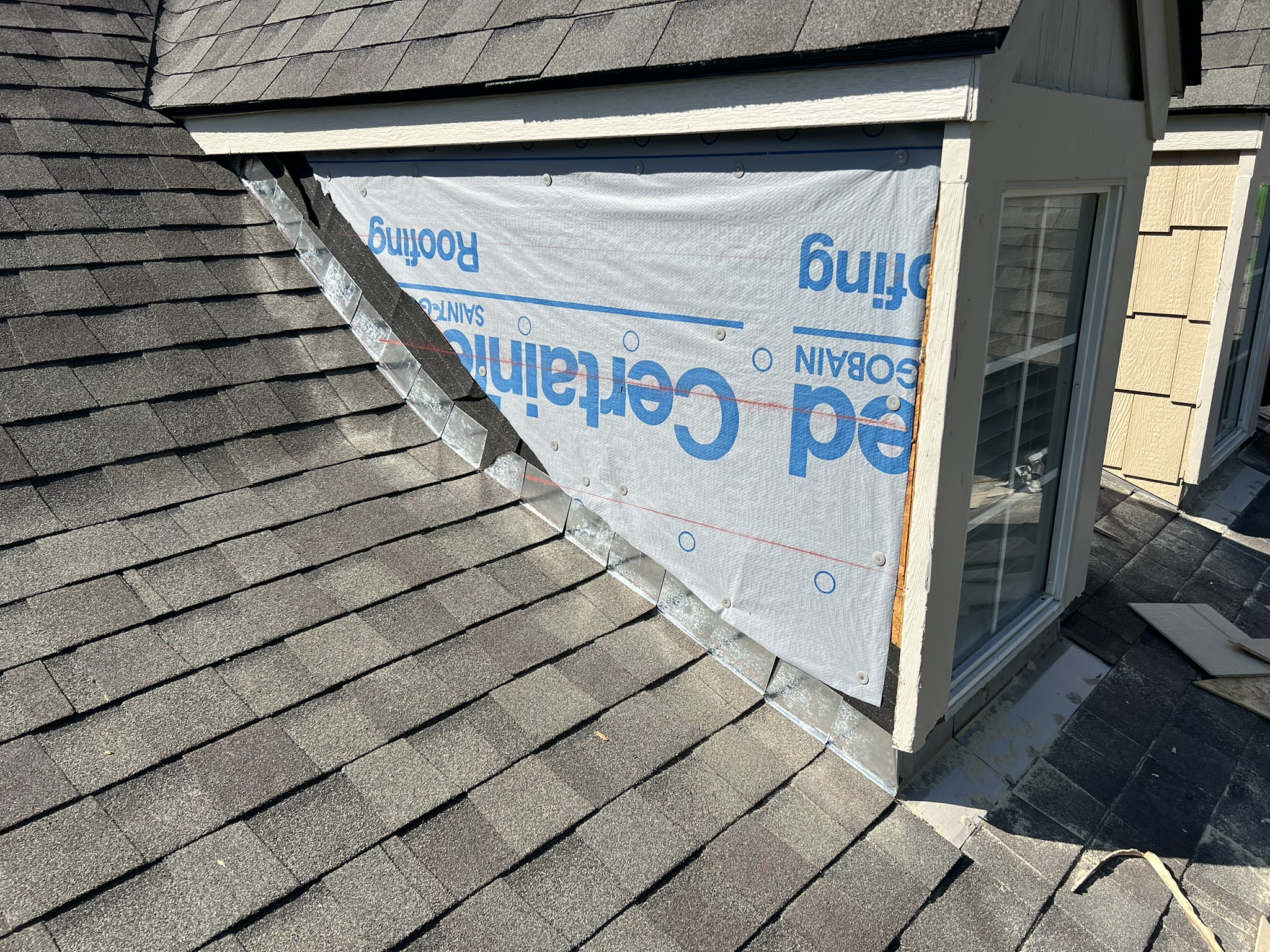 CertainTeed underlayment installed at dormer wall junction with step flashing visible