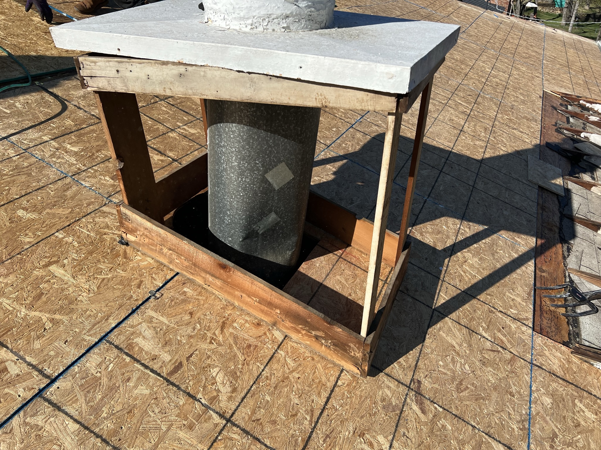 Chimney chase fully exposed showing complete flashing upgrade scope during roof replacement