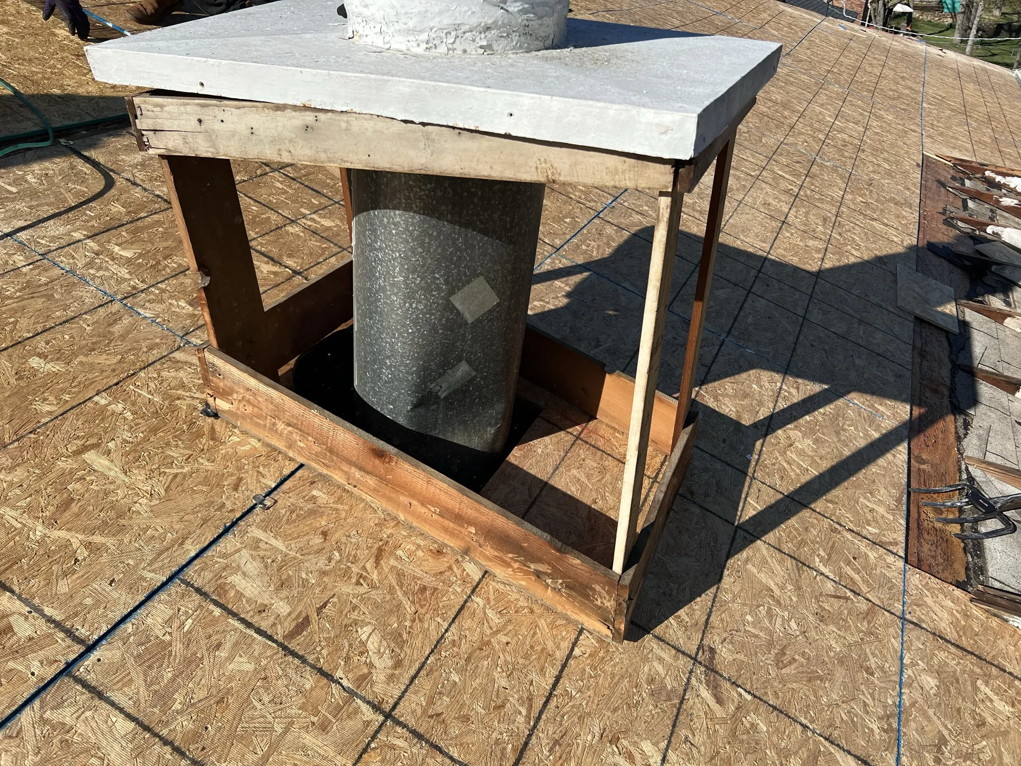 Chimney chase fully exposed showing complete flashing upgrade scope during roof replacement