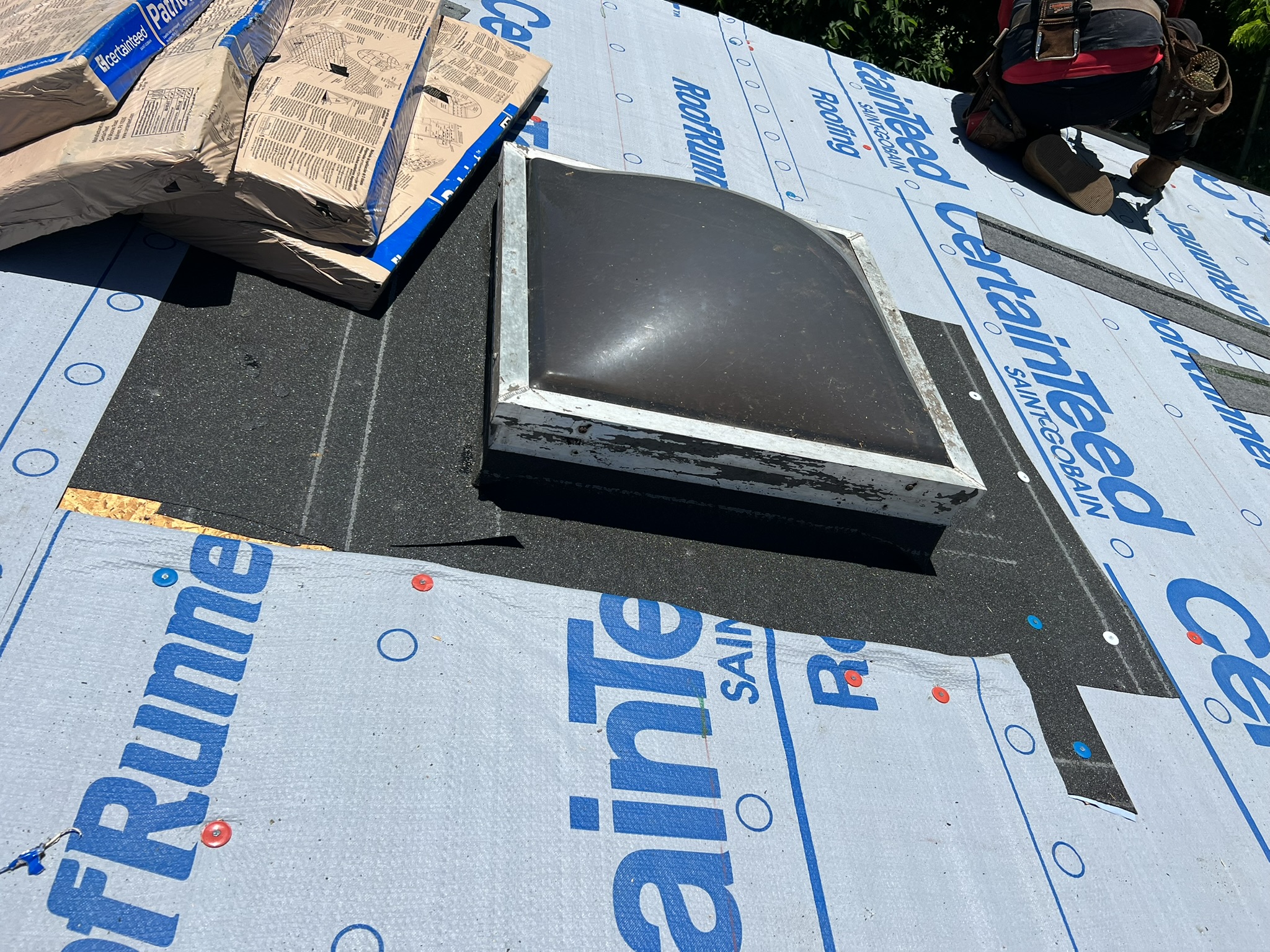 CertainTeed RoofRunner underlayment installed with skylight and Landmark shingle bundles staged