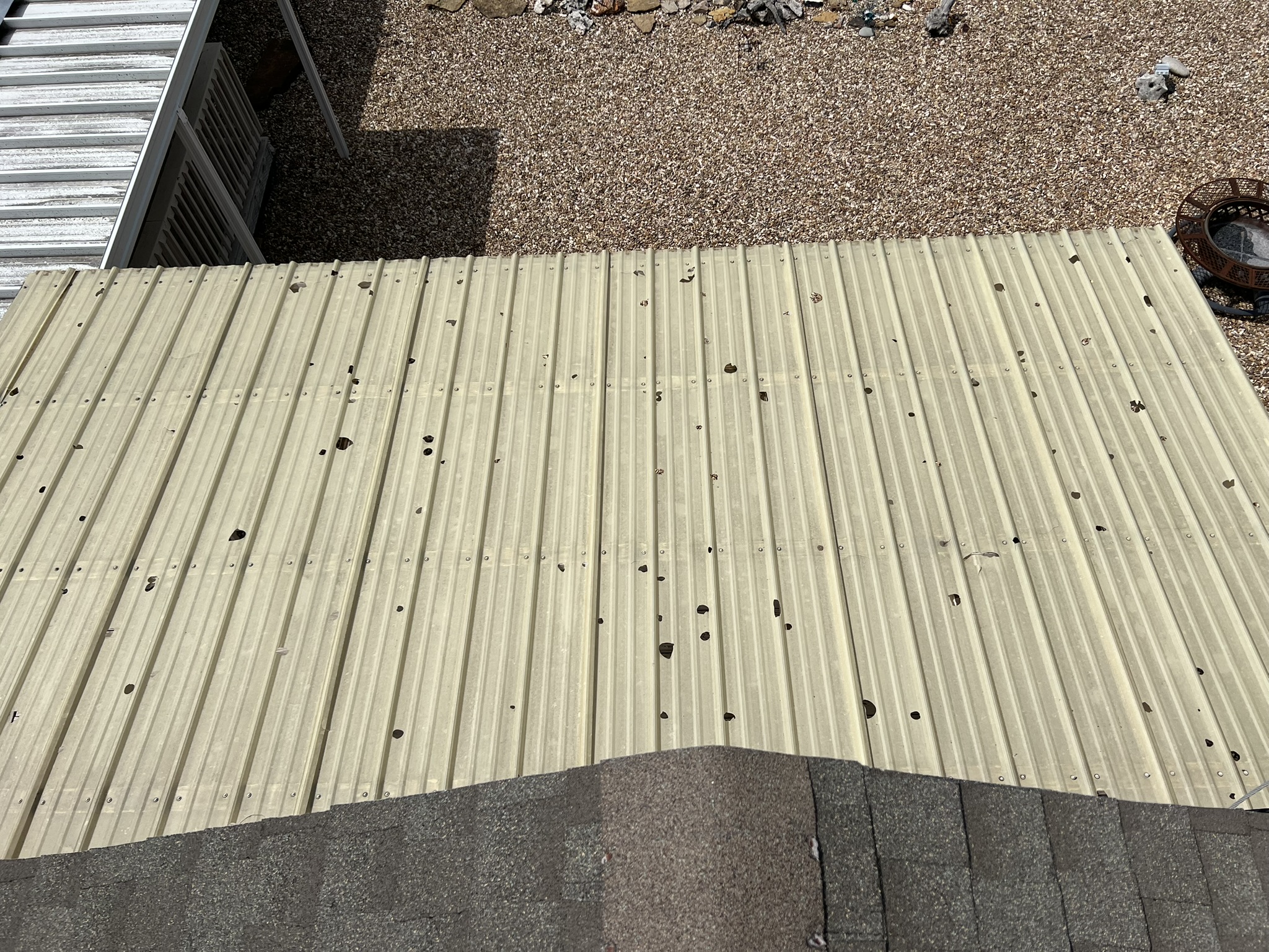 Metal roof surface with multiple hail puncture holes