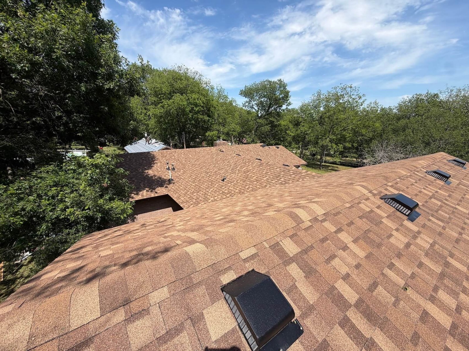 A finished Tulsa roof replacement with new box vents and pipe flashings