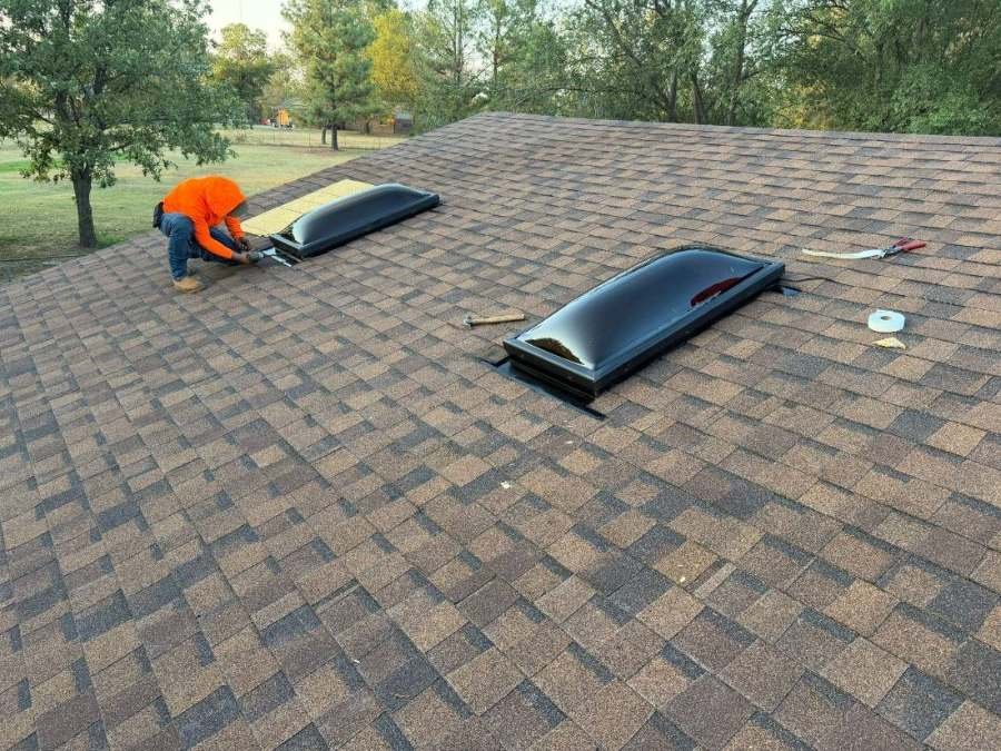 Green Country Roofing crew member flashing new skylights on a Tulsa roof replacement